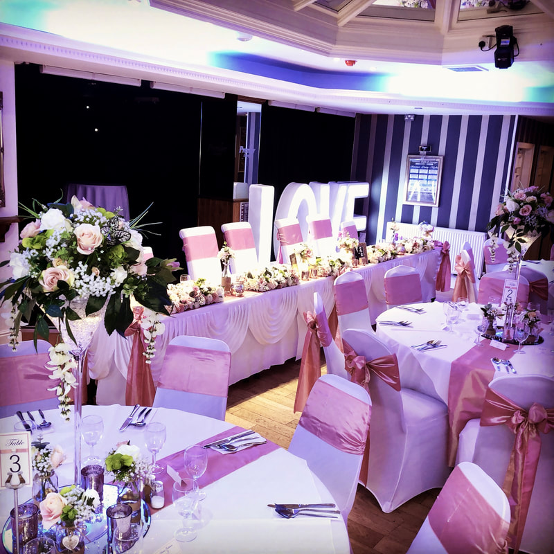 Wedding breakfast in Manchester with rose gold chairs and blush and ivory flowers.