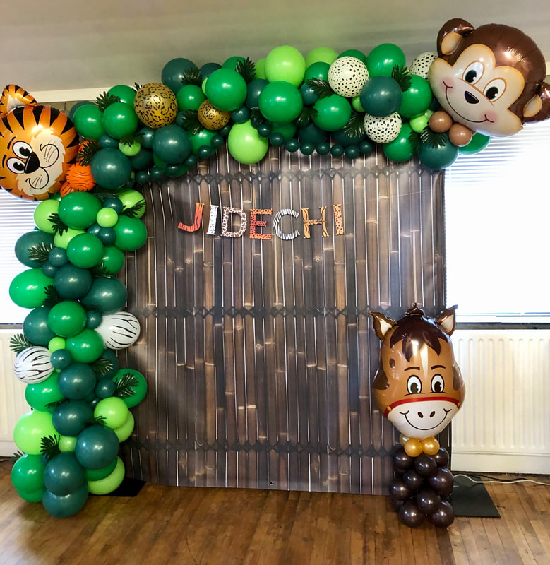 Animal birthday backdrop in Manchester with balloon garland in green and animal foil balloons.