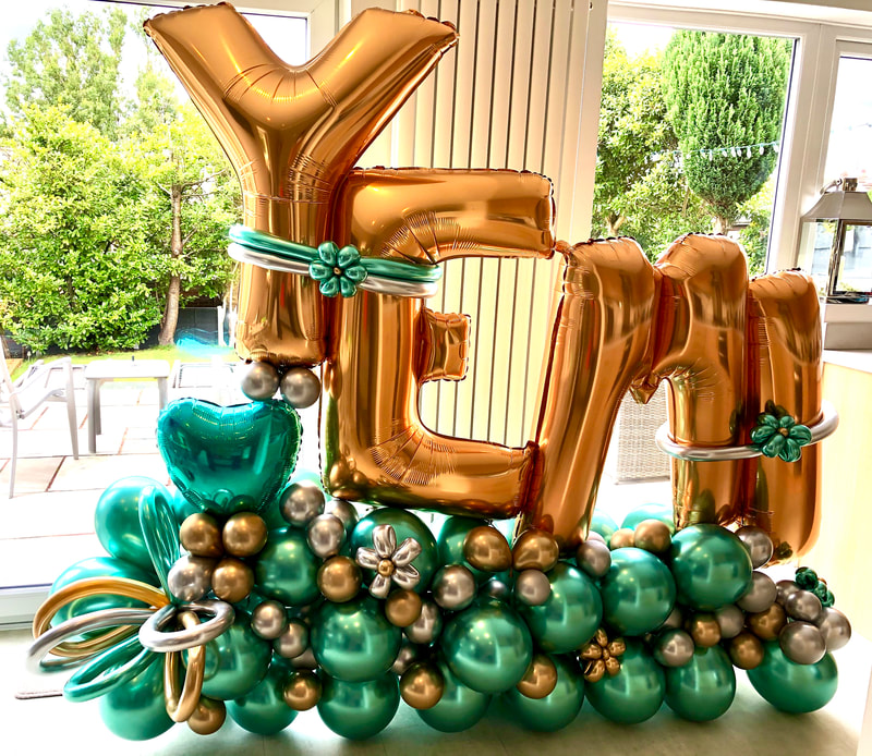 Deluxe personalised birthday balloon display in gold and green.