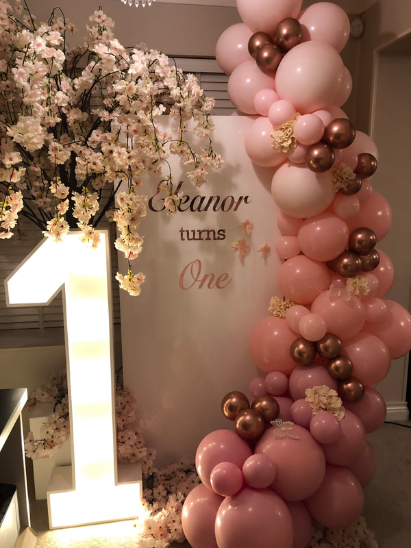 First birthday in Cheshire. Personalised backdrop with pink and rose gold balloon garland, pink blossom tree and 4ft LED number 1.