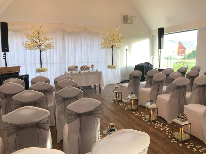 Wedding ceremony with ivory light up blossom trees with silver lanterns in Manchester.