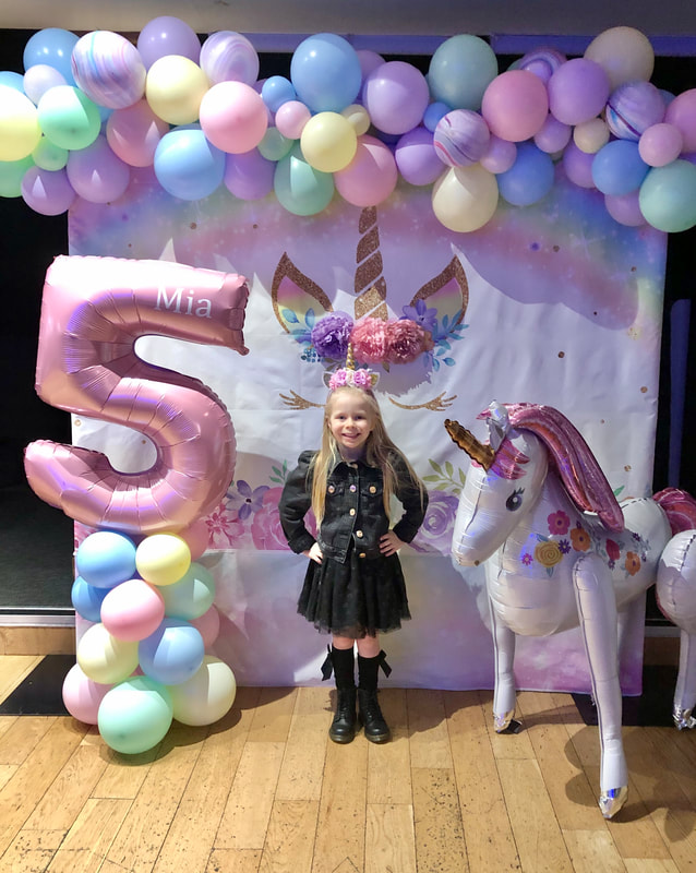 Unicorn backdrop in Manchester with multicoloured pastel balloon garland, pink 5 foil balloon tower and unicorn balloon
